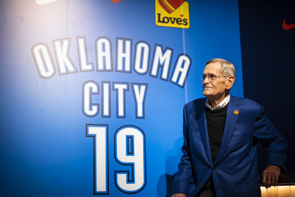 Tom in front of a backlit OKC Thunder jersey with the Love's patch
