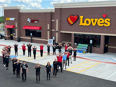 Love's Travel Stop employees in front of a store in Monroe Center, Illinois.