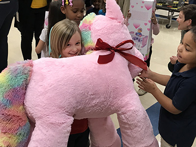 young girl with large stuffed unicorn