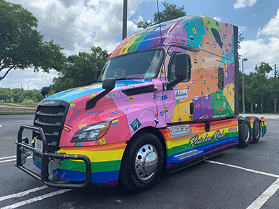 Rainbow Rider tractor with map and PFLAG colors parked in lot