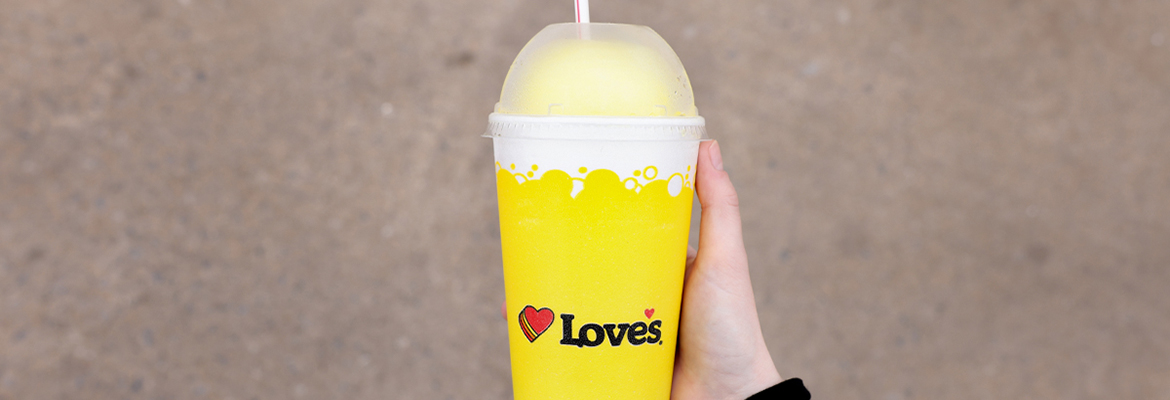 hand holding love's frozen drink in cup over payment