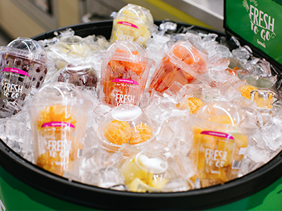 A photo of fruit cups in a cooler with ice
