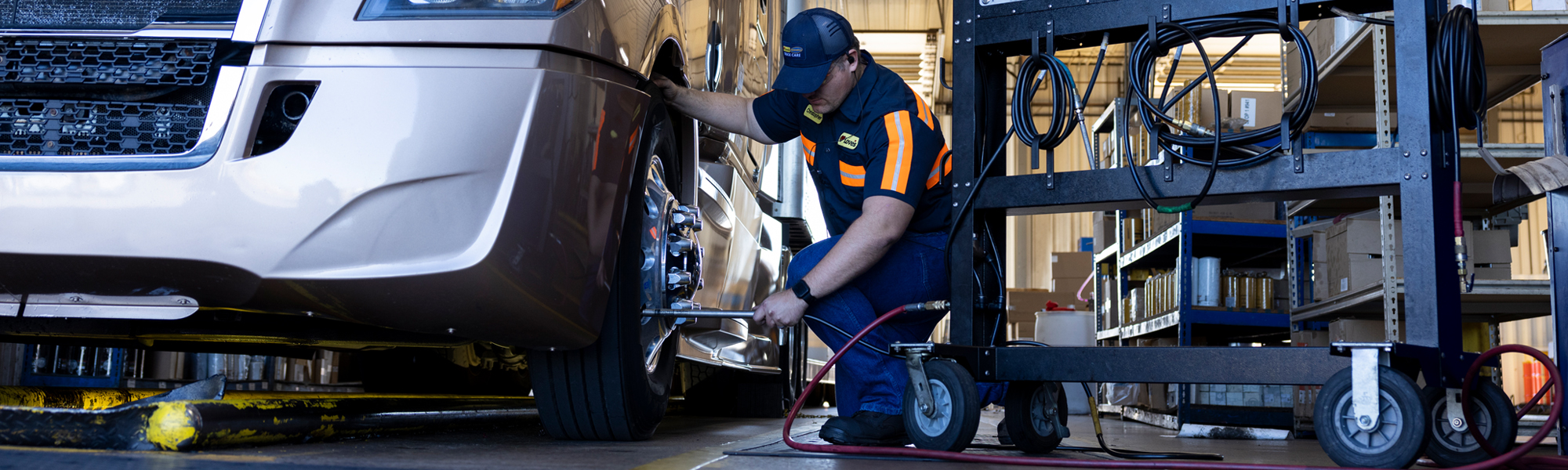 A truck care technician performing TirePass service on a truck in the service center